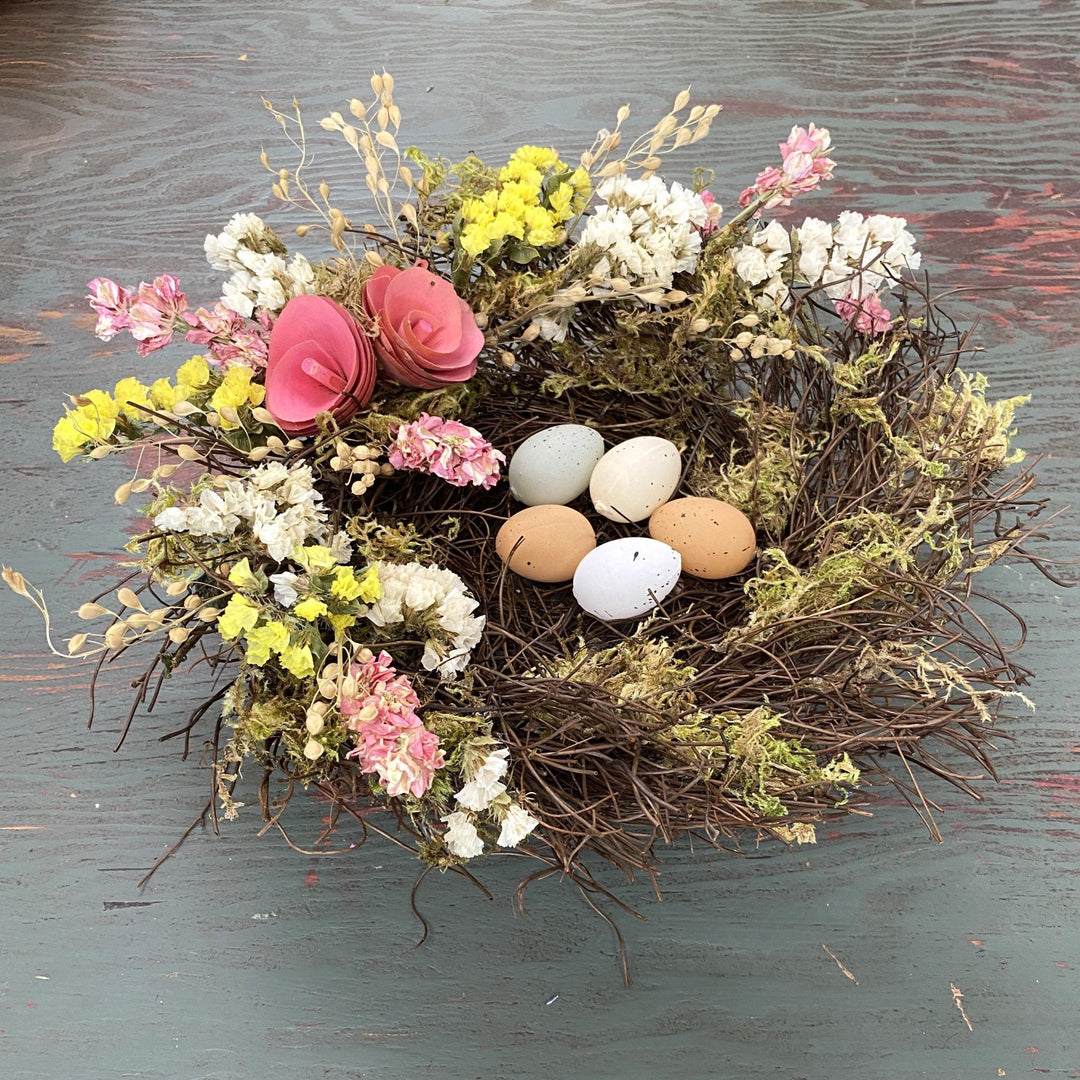 Spring Floral Nest - Creekside Farms Spring flowers and faux eggs adorn a mossy vine nest 10"